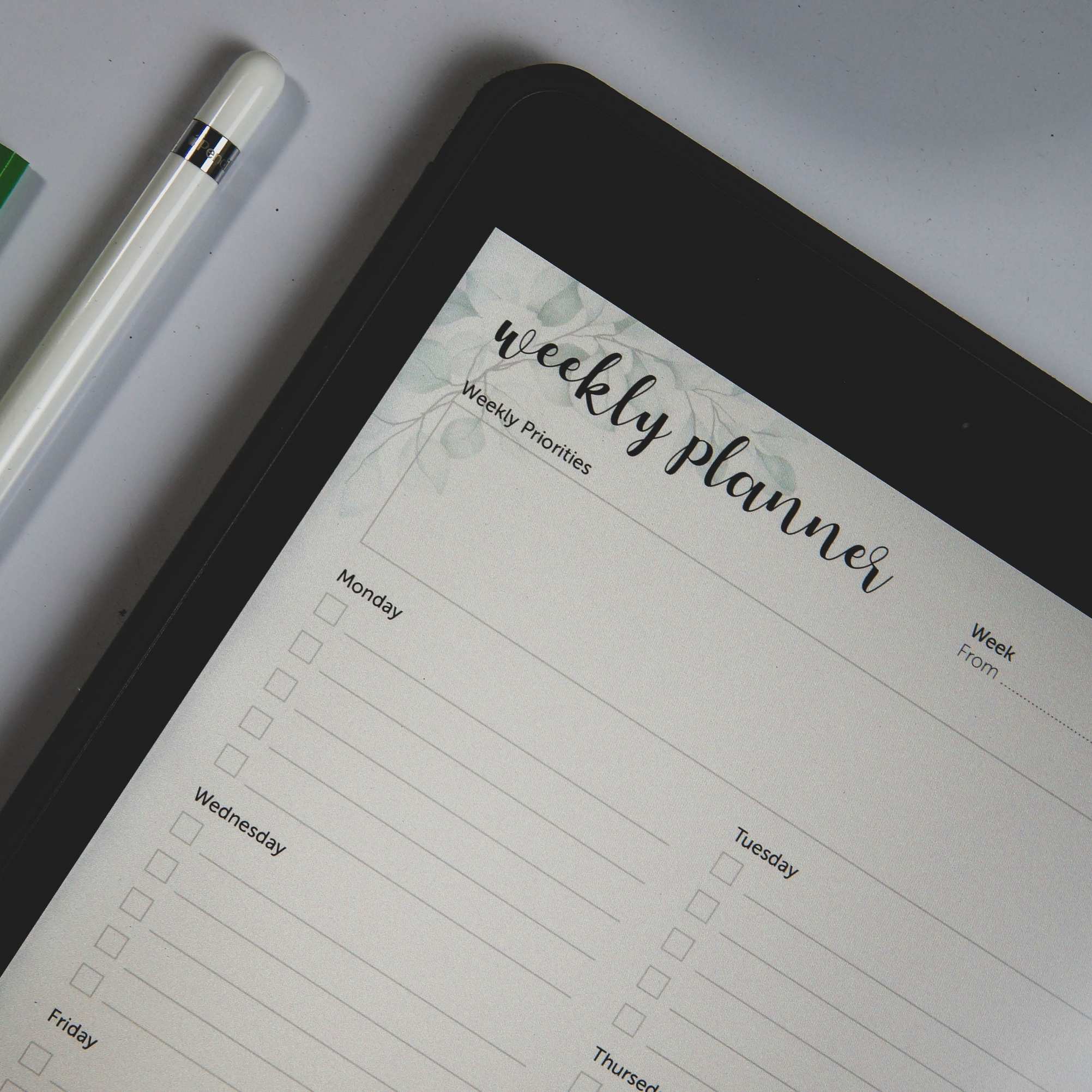 Arbeitsplatz mit Tastatur und Bildschirm, Tablet mit Wochenplan und Stift