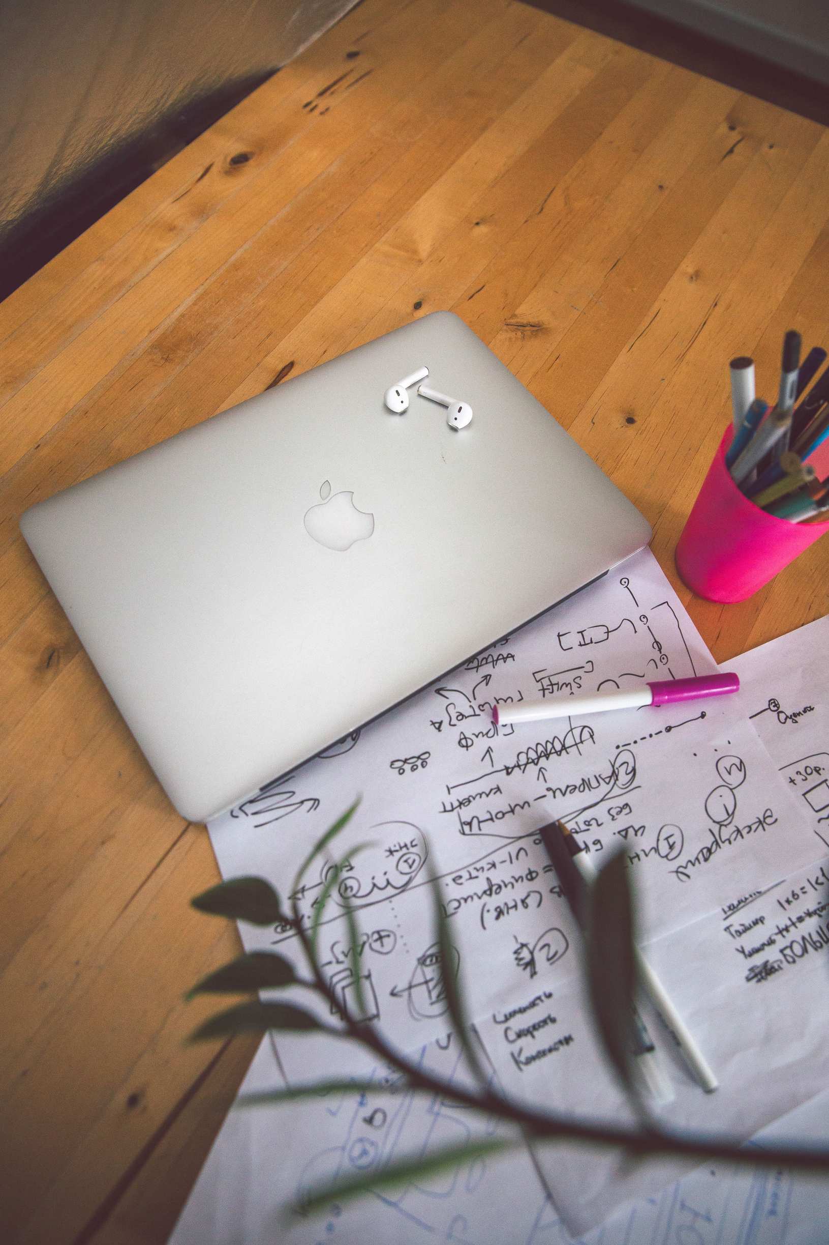 Notizbuch mit markierten Stichpunkten, Laptop und Notizen auf Schreibtisch